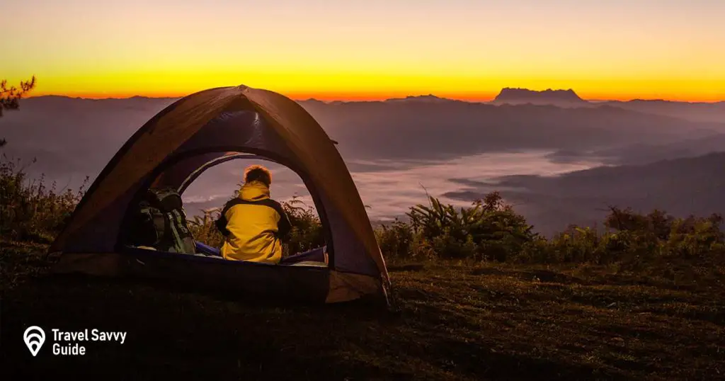 A person sitting in a tent overlooking the mountains