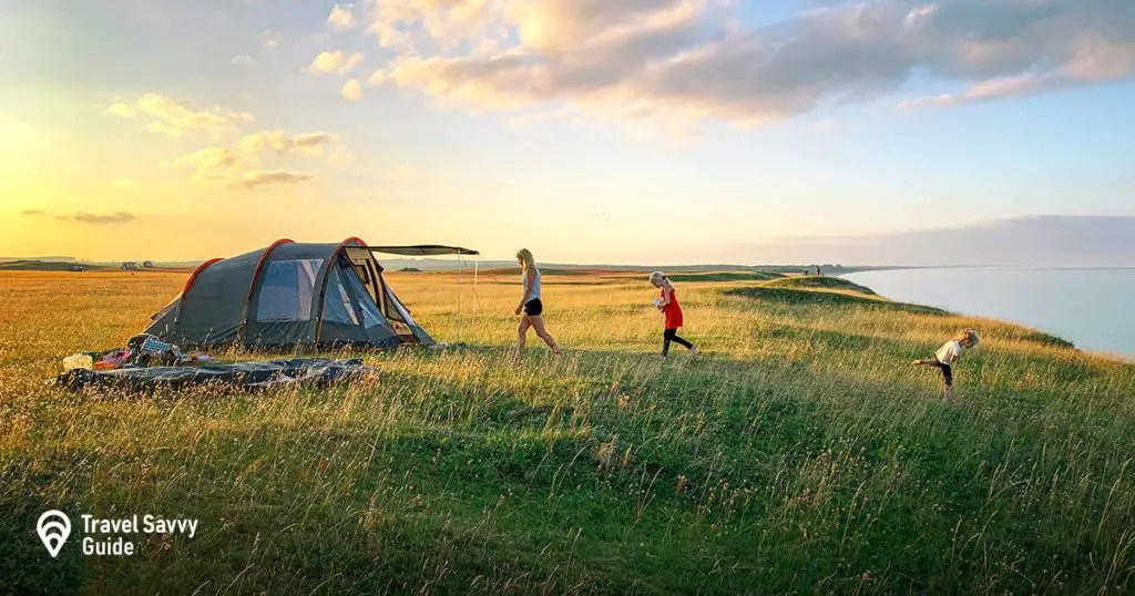 Family near a tent on the sore of the lake