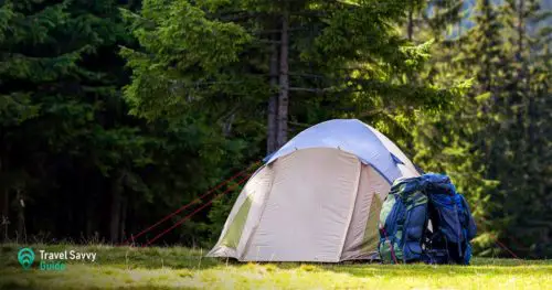 Backpack near a white tent on a forest background
