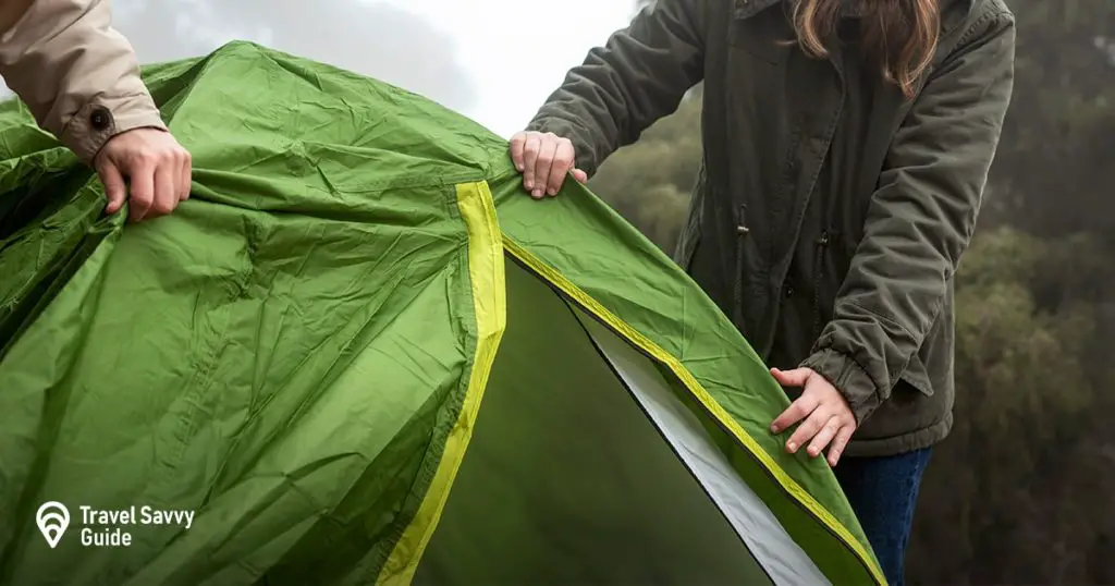 Happy couple putting up a tent in nature