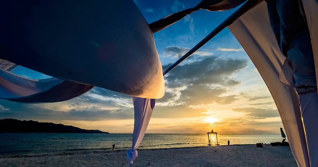 Light white sheets pf a beach canopy blowing in the wind