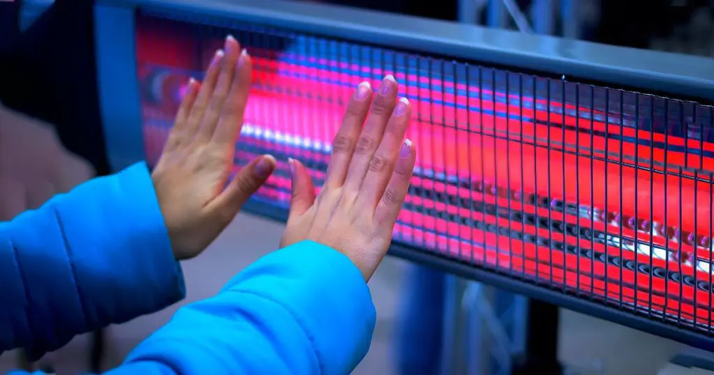 Girl Hands Warming With Heating Radiator at evening winter outdoor
