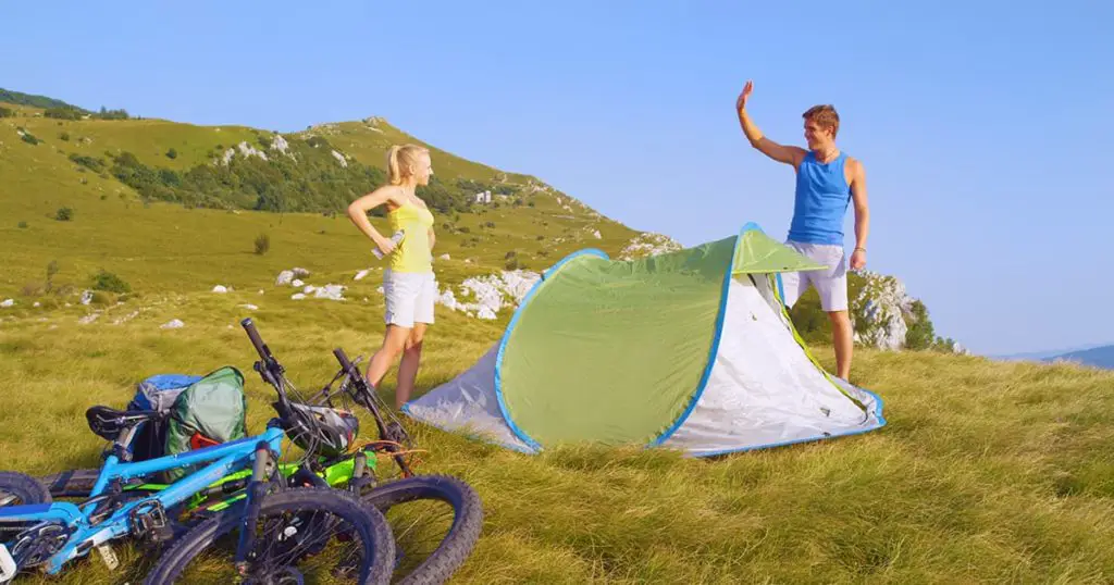 Tourists set up their pop up tent in the middle of the large meadow