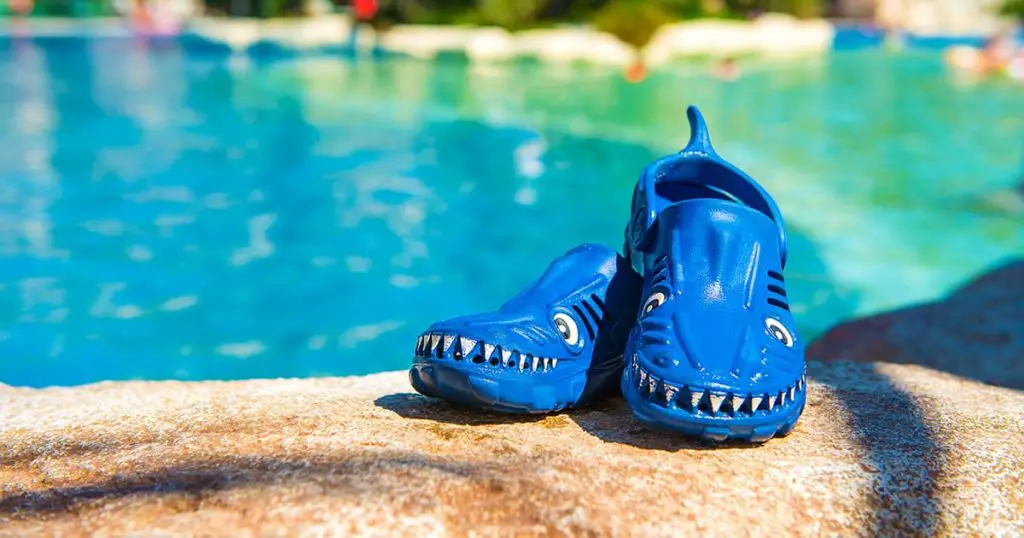 kid's waterproof clog sandals standing on the pool edge