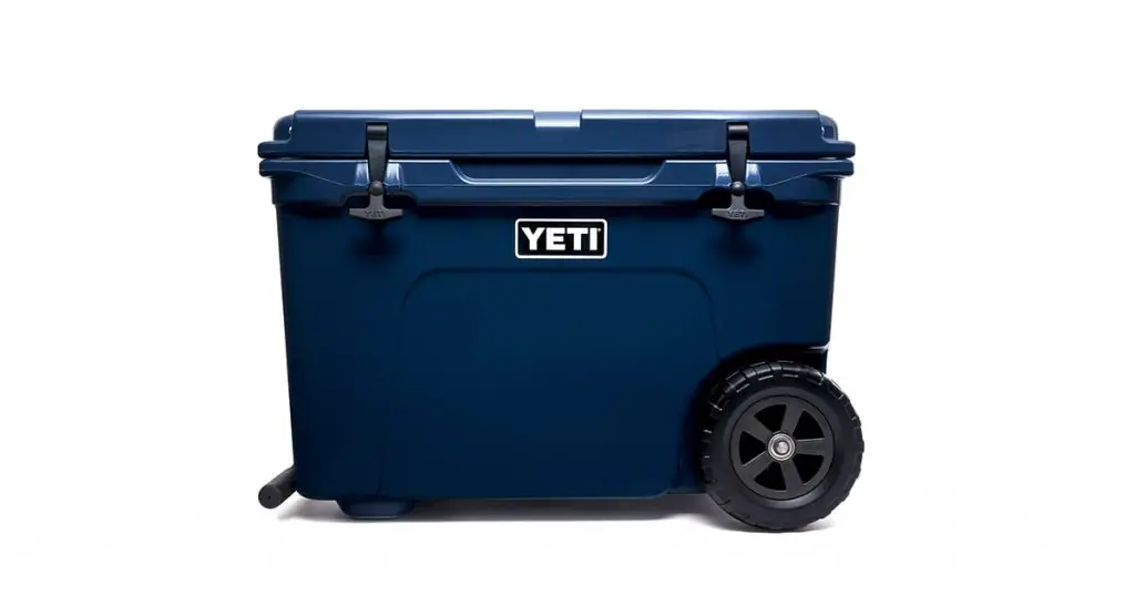 YETI navy color wheeled cooler a white background