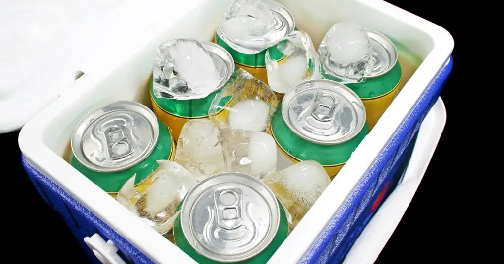 Icy cold cans of drink in a plastic cooler