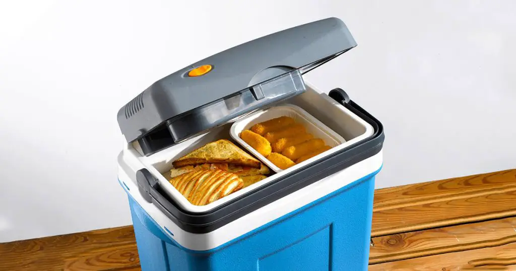 Sandwiches and croquettes into a cool box and on wooden table