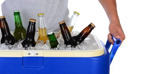 Closeup of a fit young man carrying an ice chest full of beer