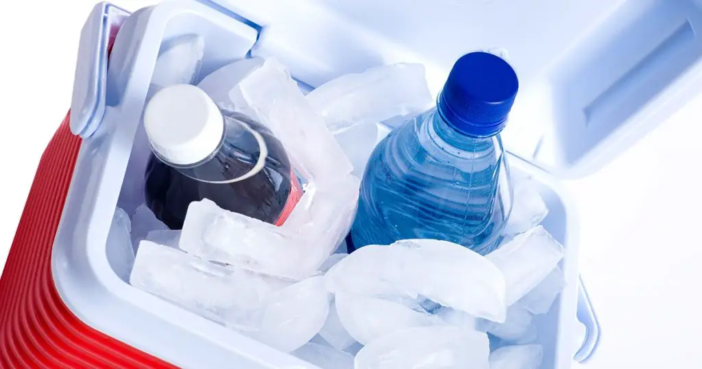 A small ice chest or cooler with drink including a cola and a bottle of water