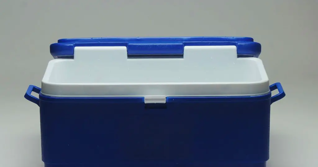 Opened Handheld blue refrigerator, ice box over white background.