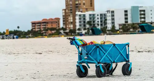 blue cart on sandy beach against hotels and dark clouds in background. High quality photo