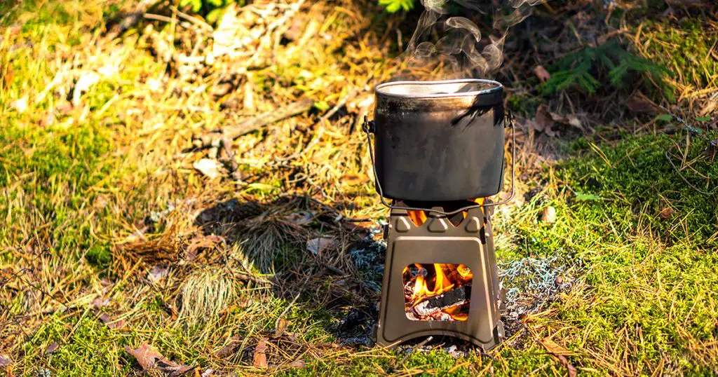 Pot boiling on wood burning twig stove outdoors