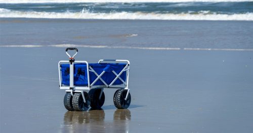 blue wagon on the beach with the waves rolling in