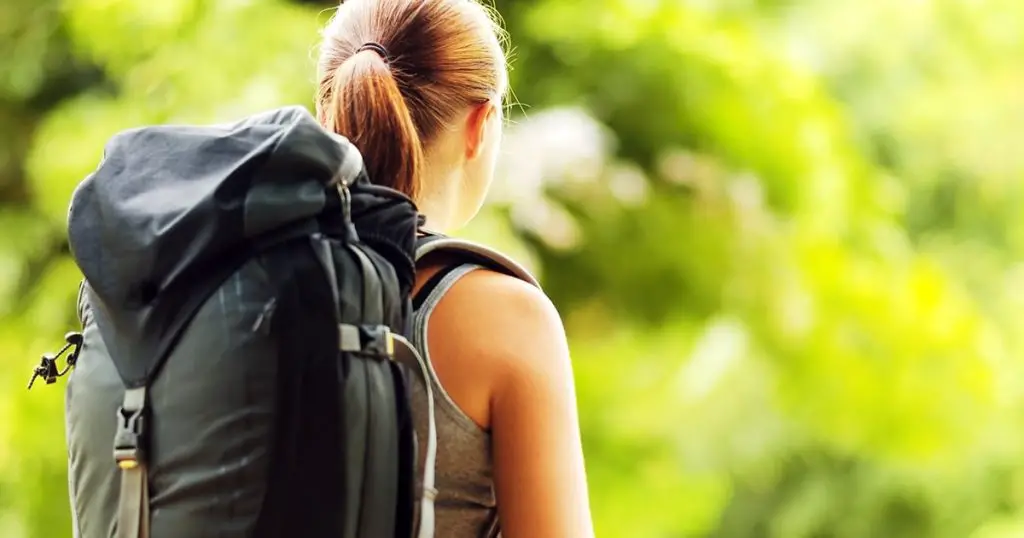 Young woman with backpack in a woods.