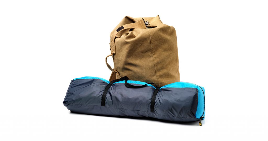 Tourist tent and backpack from fabric of color khaki on white background