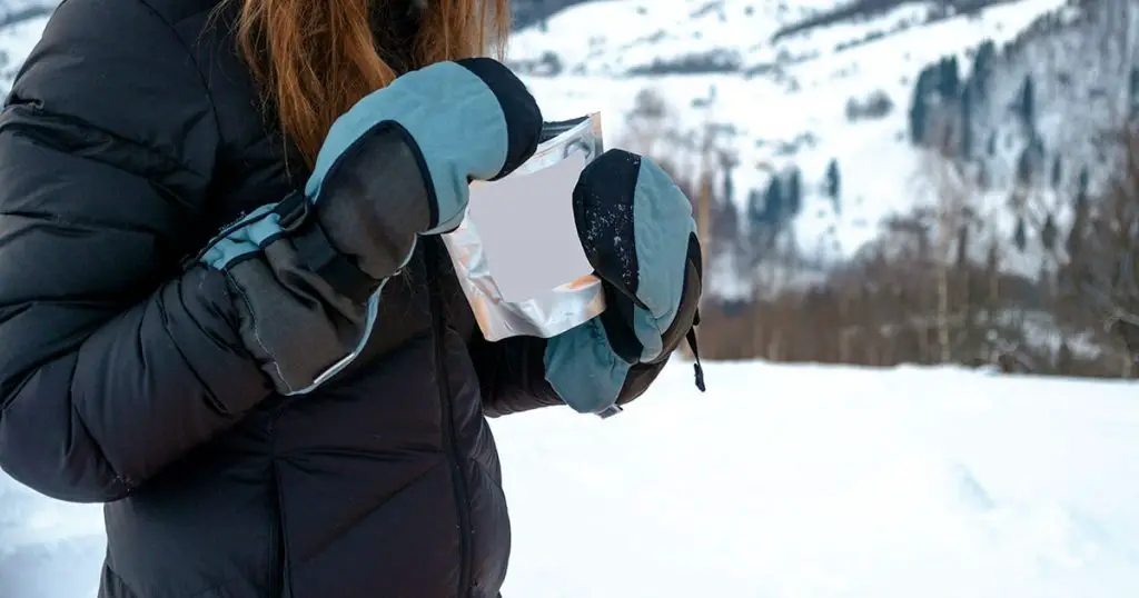 woman hiking outdoors with gloves and hat, cold outerwear gear