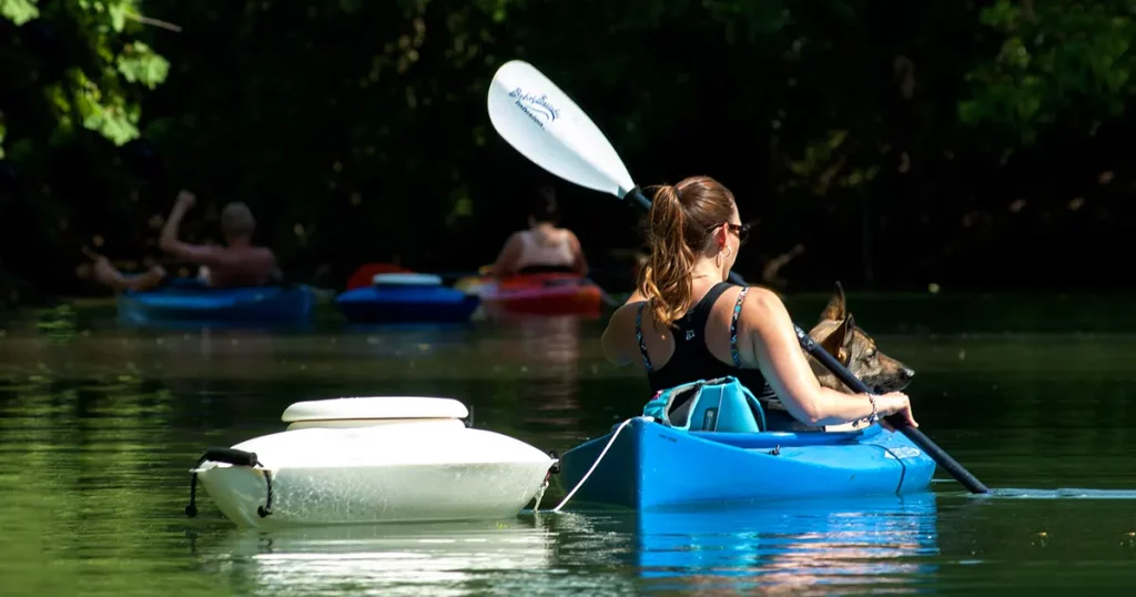Woman kayaking with a Floating Cooler in the back