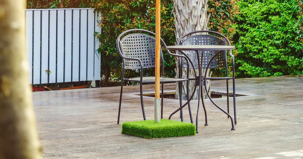 Modern table, chairs and parasol on decks. For relaxation and recreation in hotel resort.