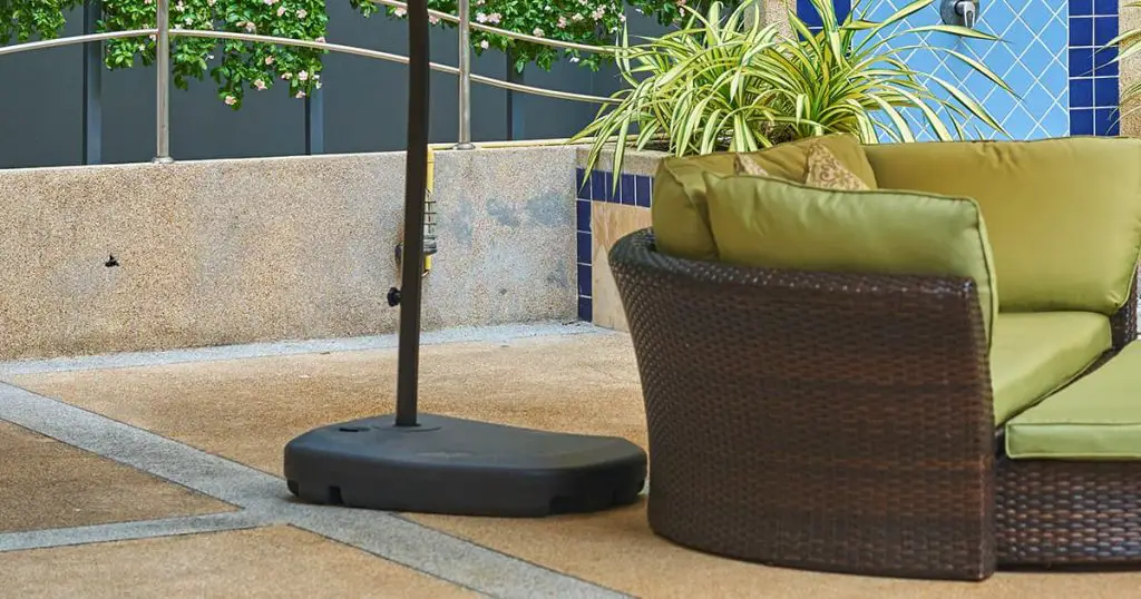 sofa with umbrella, outdoors by a hotel swimming pool