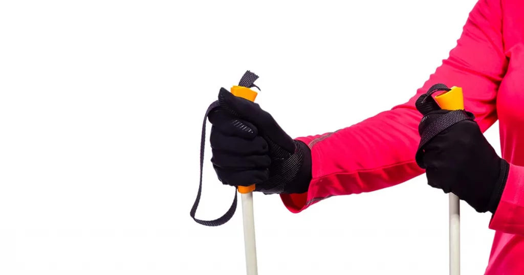 Closeup of Female Hands in Protective Gloves Holding Nordic Walking Sticks