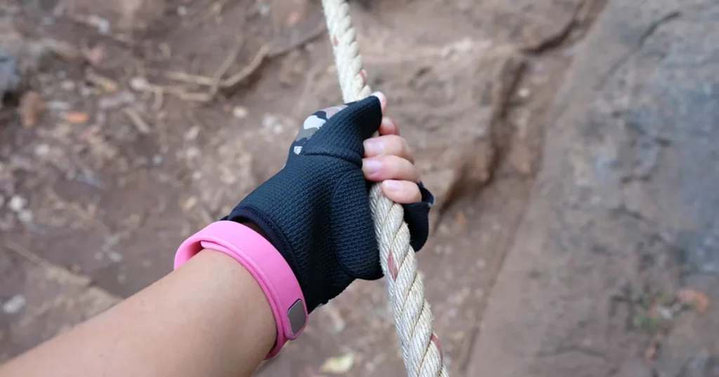 close up women climbing the mountain in hiking gloves