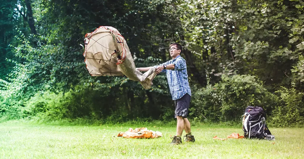 Mature man putting up tent