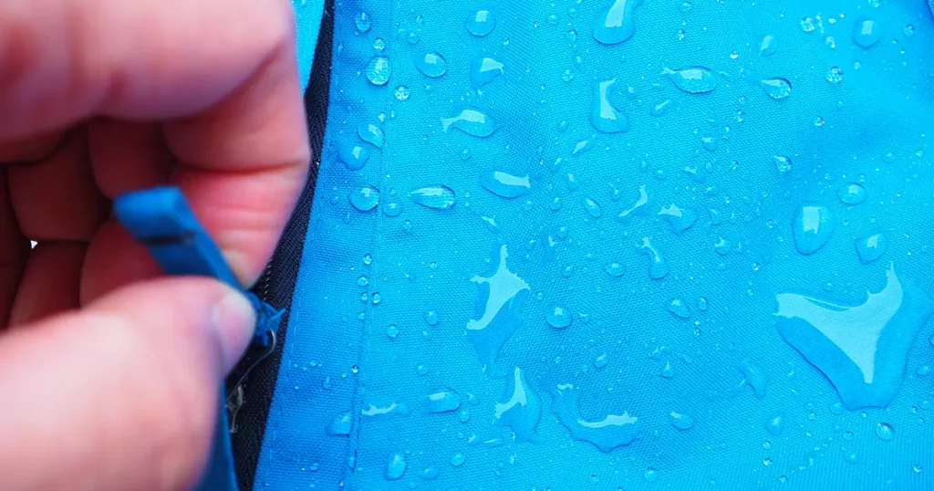 water drops on bright blue fabric and black zipper with waterproof design