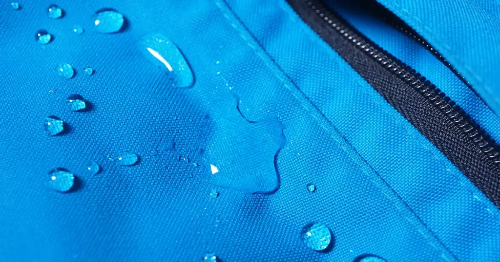 water drops on bright blue fabric and black zipper with waterproof design