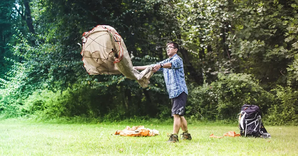 Mature man putting up tent