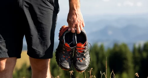 Man holding sneakers on the mountains