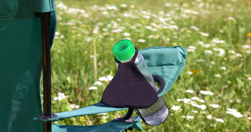 Fragment of a camping chair with a bottle of water and a bouquet