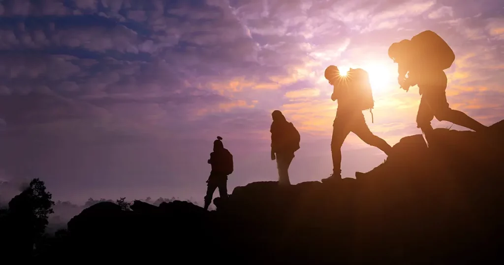 Climbing group friends walking to hike up mountain