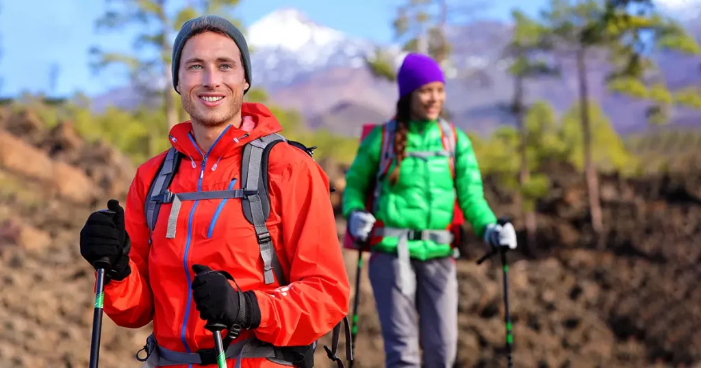 Hiking hikers couple - healthy active lifestyle. Hiker couple hiking in beautiful mountain nature landscape.