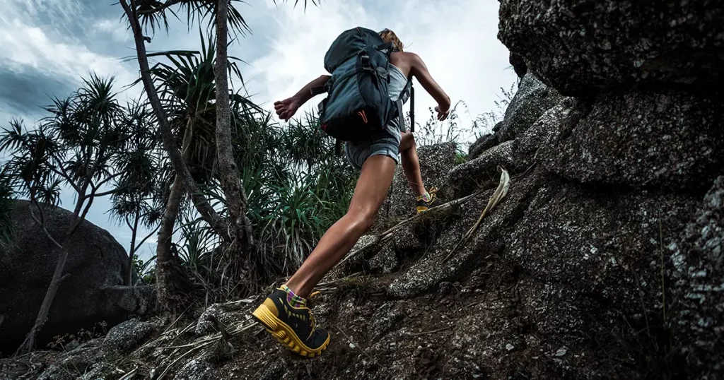 Lady hiker passing rocky terrain