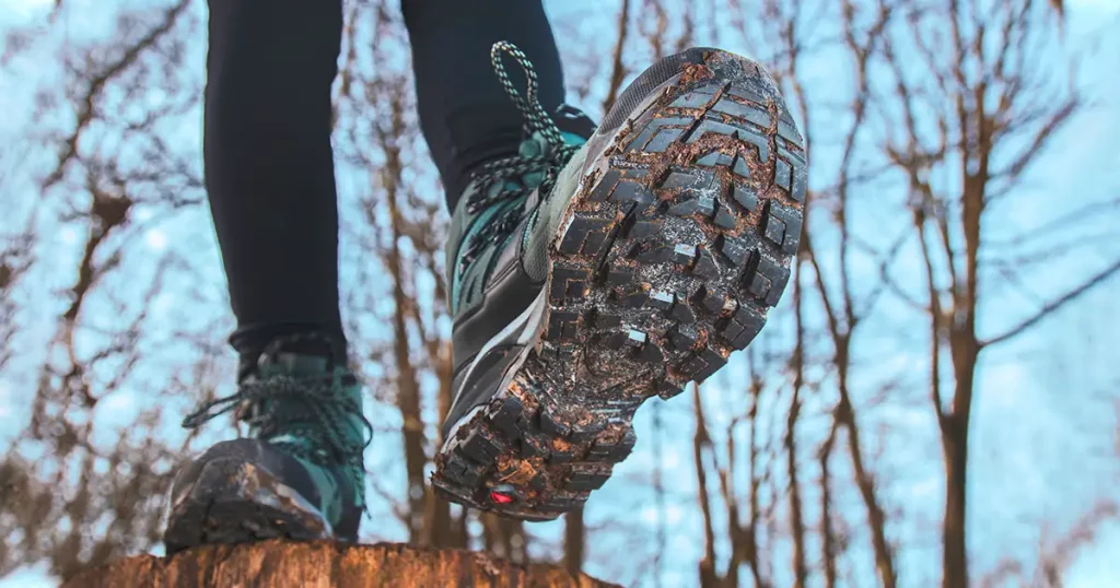 Looking up from ground level at someone walking wearing hiking boots