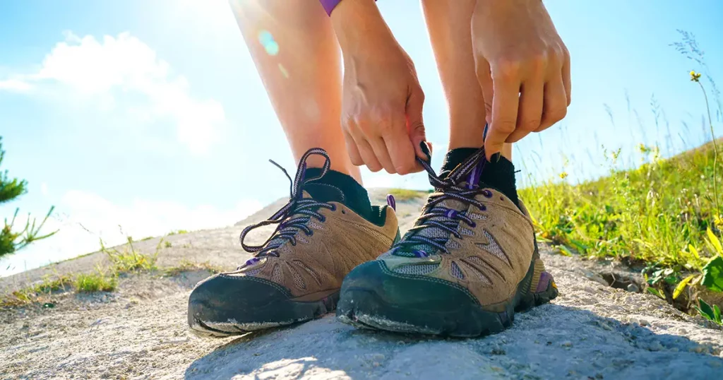 Hiking shoes - woman tying shoe laces