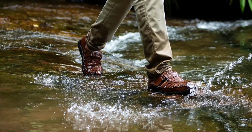 Running in water. Legs with water proof shoes. Water falls.