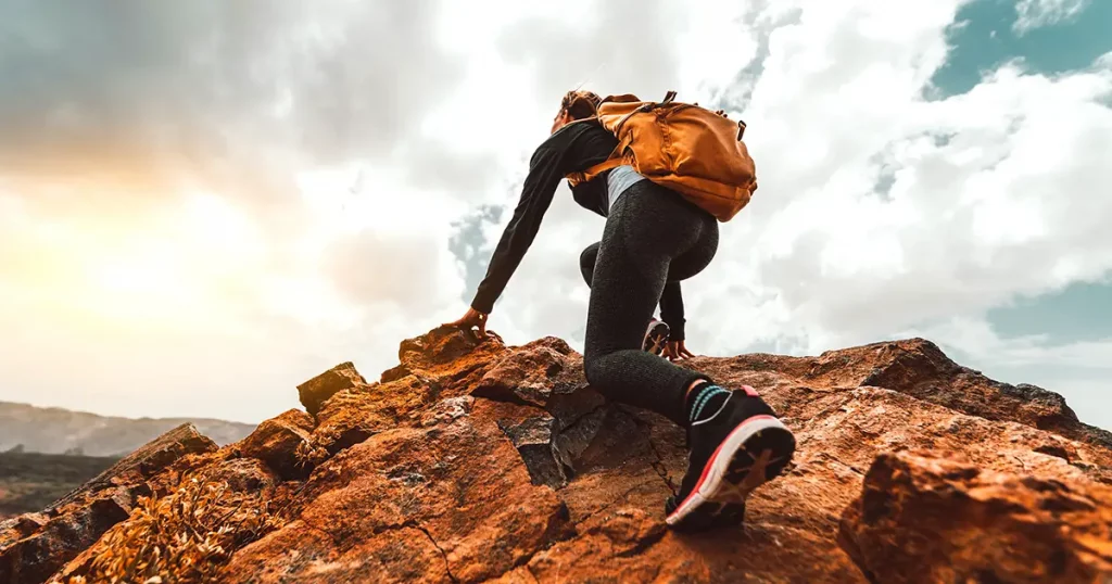 woman hiker hiking on sunrise mountain peak