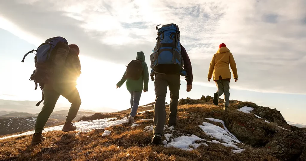 group-four-hikers-backpacks-walks-mountains
