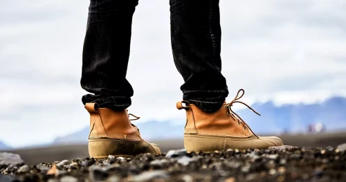 A young man in boots walking around Iceland. close up.