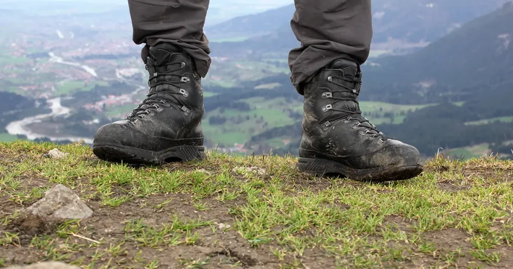 Dirty hiking boots with pants after reaching the summit.