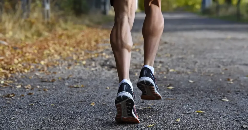 sport man with ripped athletic and muscular legs running off road in jogging training