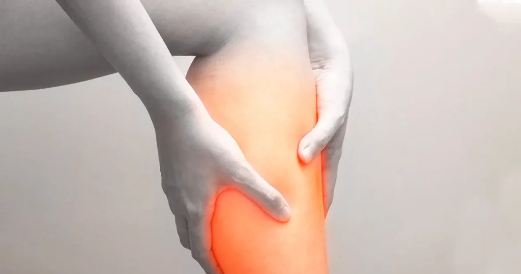 Young woman holding her calf muscle in pain with red highlighted, Isolated on white background