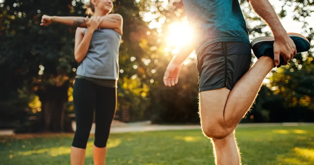 shot-young-man-woman-stretching-park