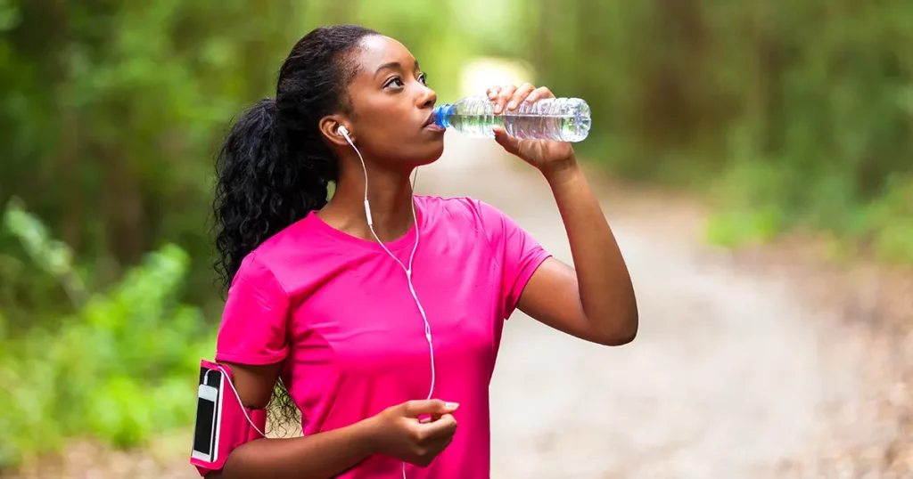 african-american-woman-jogger-drinking-water