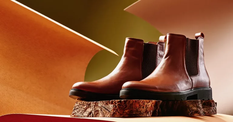 Brown leather chelsea boots made of genuine leather in classic style on a wooden cut.