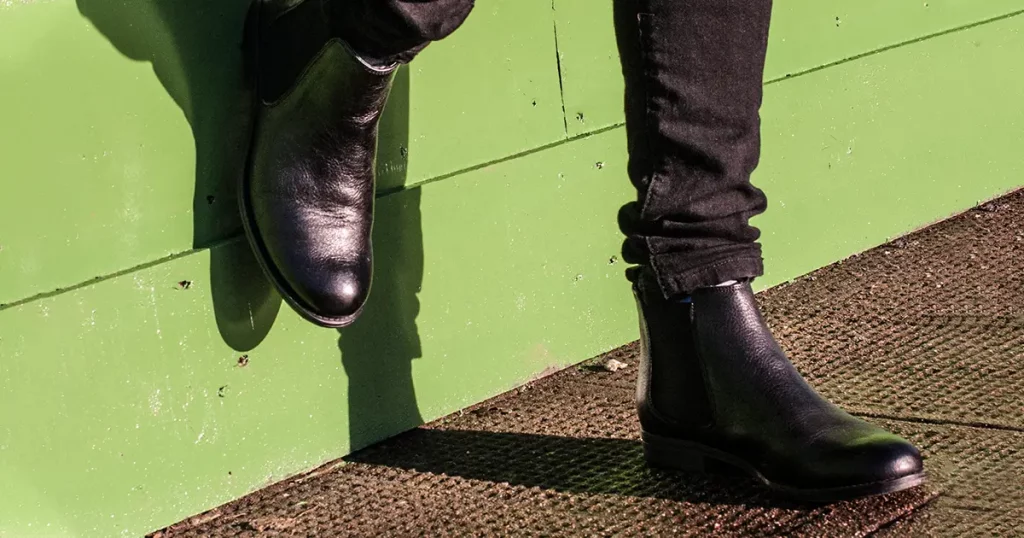 Model wearing black trousers and ladies vintage boots with low heel (short Chelsea ankle) on the street