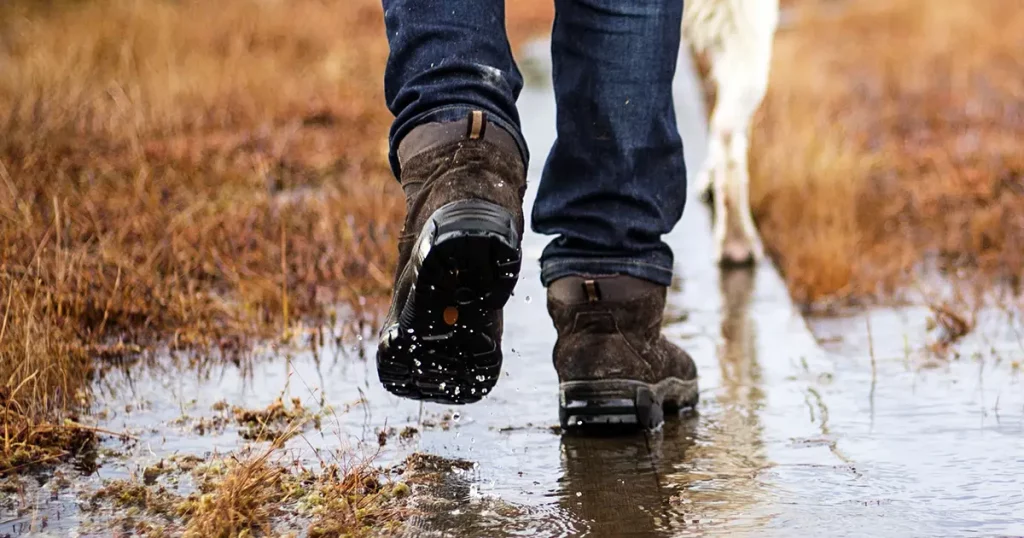 man hiking boots jeans walking dog