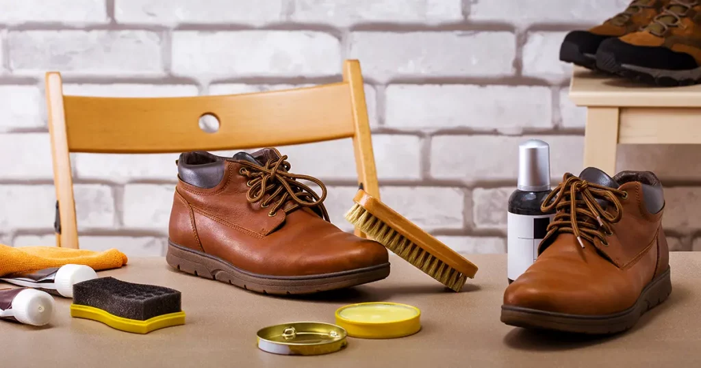 Polish creams, various cleaning brushes for shoes and leather shoes on the table
