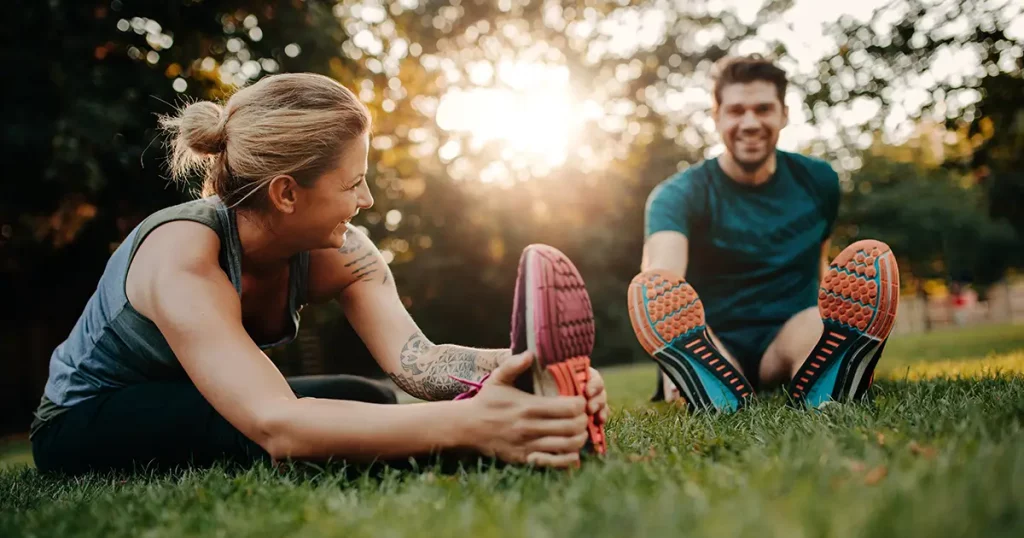 fitness-couple-stretching-outdoors-park-young